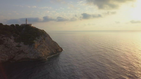 Aerial of Lighthouse on Rock Cliff on Mallorca at Sunrise