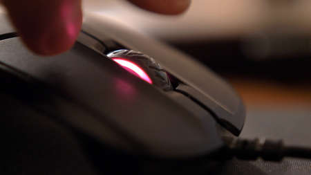Caucasian Male Hand Using Computer Mouse Buttons and Wheel in the Dark Close Up