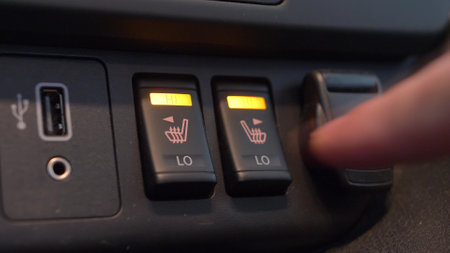 Heated Car Seat Switches Being Toggled to Control Seat Warmersの写真素材