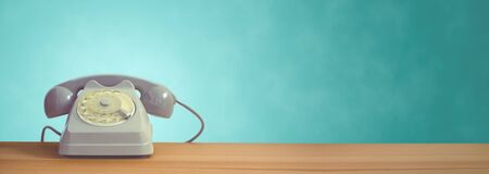 A vintage dial telephone with turquoise background.