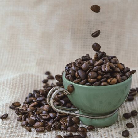 Cup of coffee beans on jute bag.の写真素材