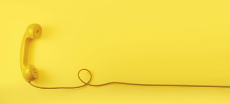 A yellow vintage dial telephone handset with yellow background.の写真素材