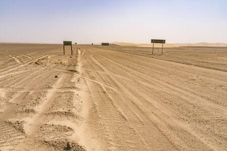 View of the Skeleton Coast desert dunes in Namibia in Africa with road signs.の写真素材