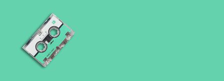 Green blue mini cassette audiotape on green blue background.の写真素材