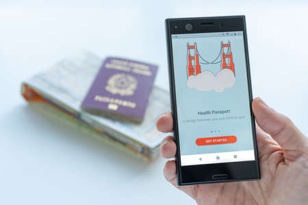 Milan, Italy - 01 26 2020: Digital Health Passport app for smartphone. background with a map and a...
