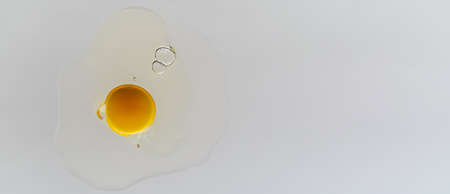 Cracked chicken egg with yolk and albumen on transparent surface and white background.の写真素材