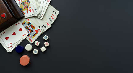 Playing cards and dice on a dark grey background. Game box.の写真素材