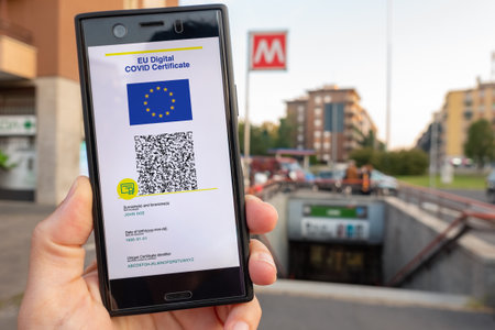 Woman showing on smartphone EU Digital Covid Certificate Green Pass with quad code. Underground background.の写真素材