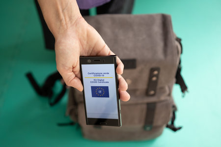 Woman with backpack showing on smartphone Italian EU Digital Covid Certificate.の写真素材