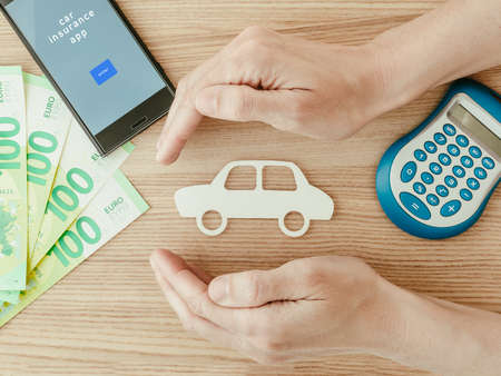 Car insurance concept with euros, smartphone and calculator. Close upの写真素材