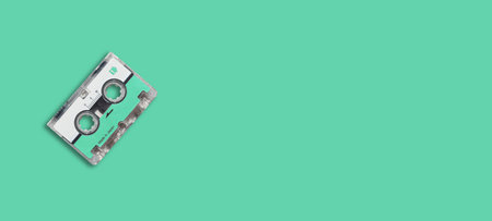 Green blue mini cassette audiotape on green blue background.の写真素材