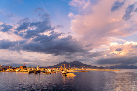 Naples, Italy - 08 06 2020: Harbor at sunset with shipyards and Vesuvius volcano.のeditorial素材