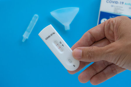 Making Coronavirus Covid-19 antigen test with positive result on white background.の写真素材