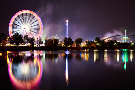 Big wheel on funfair with reflection in riverの写真素材