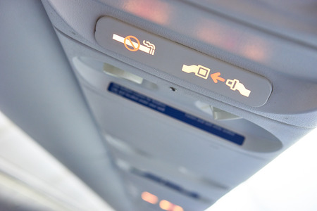 Security on a plane / Fasting Seat belt sign on a plane / No Smoking signの写真素材