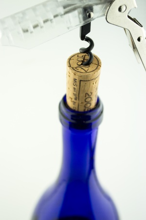Wine in blue bottle with corkscrew isolated on white backgroundのeditorial素材