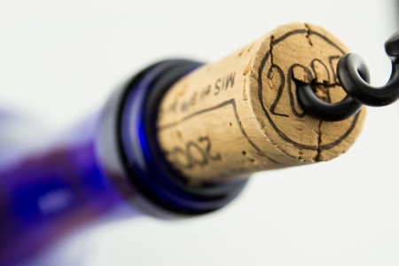 Wine in blue bottle with corkscrew isolated on white backgroundの写真素材