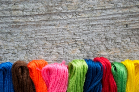 Colorful cotton craft threads on wood background with copy space の写真素材