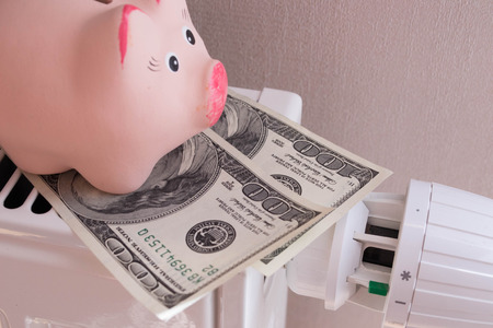 Pink piggy bank saving electricity and heating costs, close up