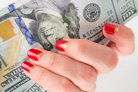 girl with red manicure gives money. denominations hundred dollarsの写真素材