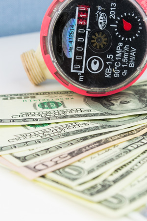 A water meter on a heap of US 100 dollar notesの写真素材