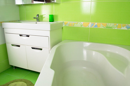 Green bathroom interior. Corner bath