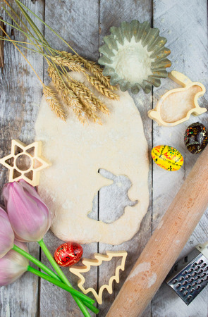 Easter baking preparation. Raw dough and form for the holiday cookies on a wood table.の写真素材