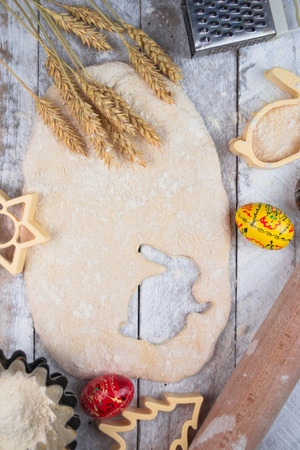 Easter baking preparation. Raw dough and form for the holiday cookies on a wood table.の写真素材