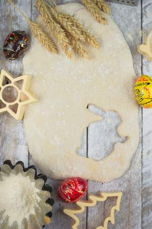 Easter baking preparation. Raw dough and form for the holiday cookies on a wood table.の写真素材