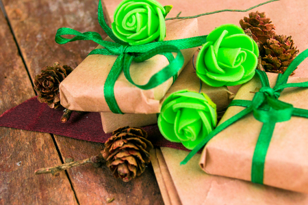 Green presents wrapped in natural paper on old wooden background.の写真素材