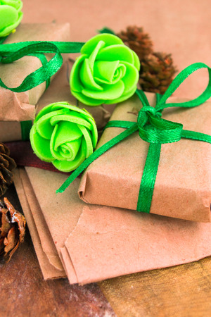 Green presents wrapped in natural paper on old wooden background.の写真素材