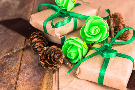Green presents wrapped in natural paper on old wooden background.の写真素材