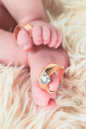 Close up of baby's feet with wedding rings. Newborn. Selective focusの写真素材