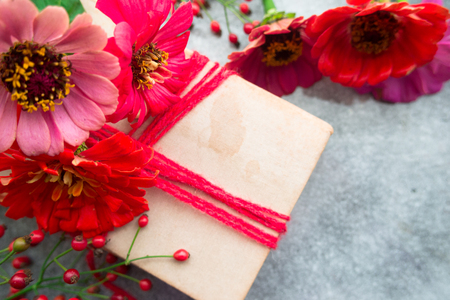 Old book with red zinnias and autumn berriesの写真素材