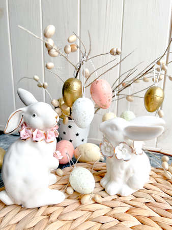 Easter decoration with white bunny and colorful eggs on wooden background.