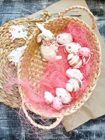 Easter eggs in a basket on a rustic wooden background.の写真素材