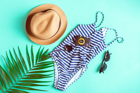 vintage set swimming suit, straw hat, sunglasses and retro camera on blue background with copy space. top viewの写真素材