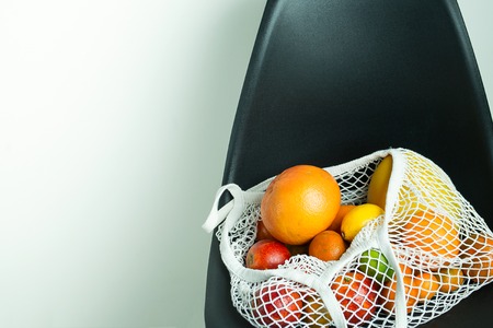citrus fruits in cotton mesh reusable bag minimalistic concept