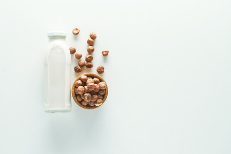 vegan milk in glass jar with ingredients on white background with copy spaceの写真素材