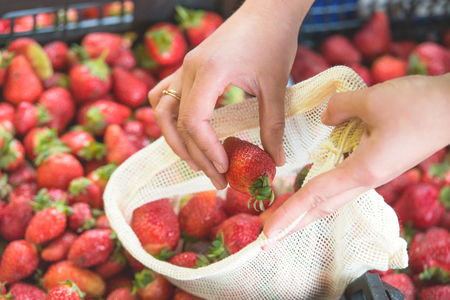 woman is selecting fruits and vegetables on farmers market without plastic bags using cotton. lifestyleの写真素材