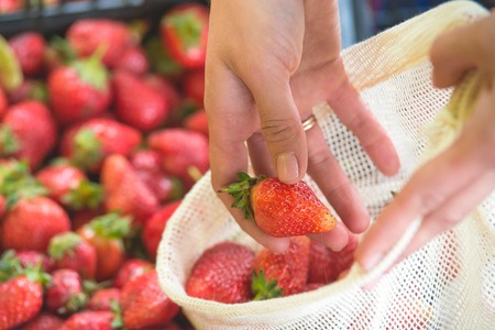 woman is selecting fruits and vegetables on farmers market without plastic bags using cotton. lifestyleの写真素材
