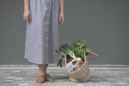 woman is holding straw back for shopping with products without plastic packaging. minimalistic conceptの写真素材