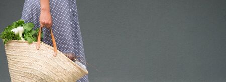 woman is holding straw back for shopping with products without plastic packaging. minimalistic...