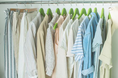 summer wardrobe with linnen clothes on green hangersの写真素材