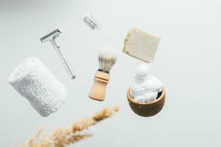 set for shaving with metal safe razor, wooden brush and soap. levitation concept flying objectsの写真素材