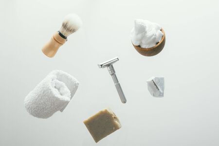 set for shaving with metal safe razor, wooden brush and soap. levitation concept flying objectsの写真素材