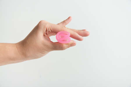 hand is holding menstrual cup on white background