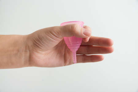 hand is holding menstrual cup on white backgroundの写真素材