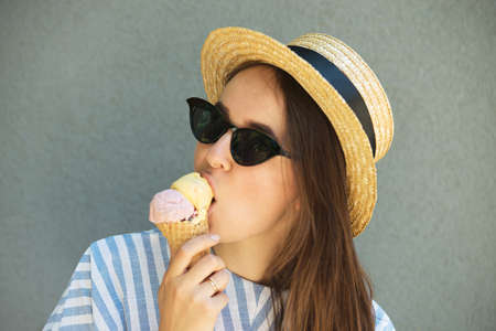 girl hipster in straw hat is eating ice cream