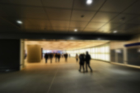 People walking in dark station tunnel. Blur effect